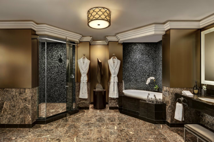 the walk-in shower features beautiful black and white mosaic tile, offering a wonderful contrast to the marble floor tiles