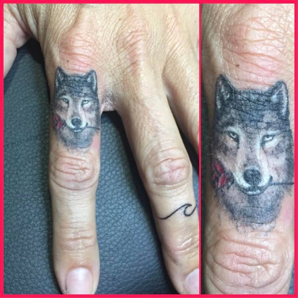 Wolf Holding Rose Index Finger Tattoo