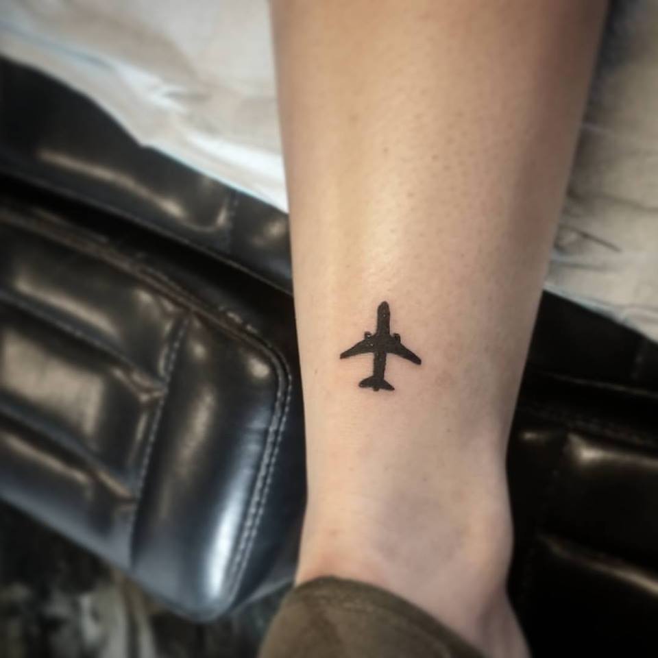 Black Aeroplane Tattoo Inked On Leg