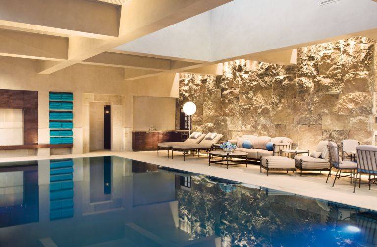 Indoor Infinity Edge Swimming Pool With Awesome Stone Wall
