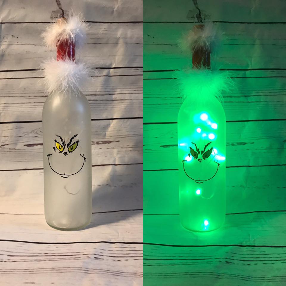 Wine Bottle Is Decorated With Light And Pom Pom