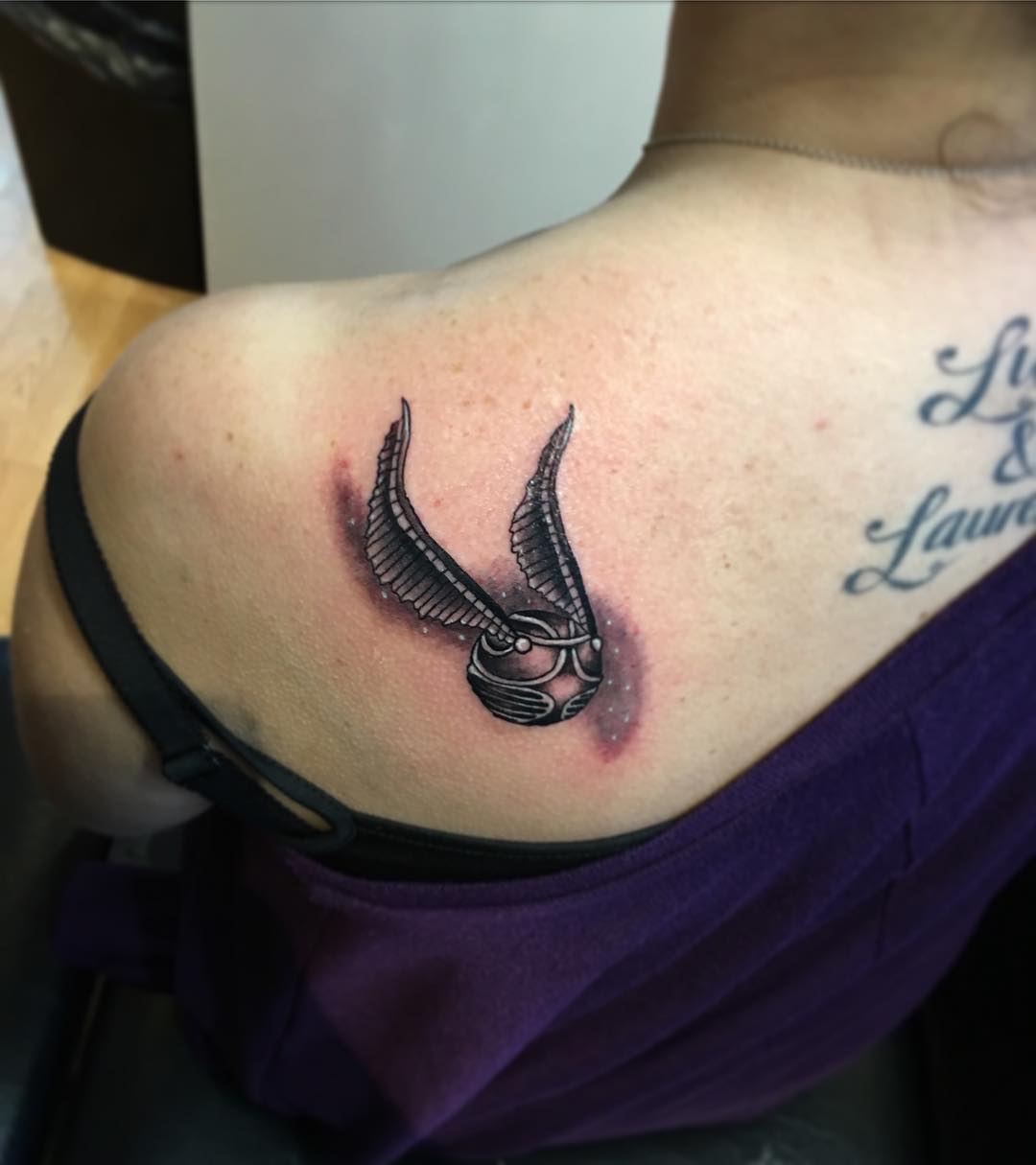 A Golden Snitch Tattoo From Harry Potter Chapter On Back Shoulder