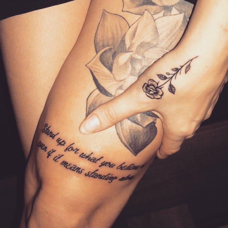 Lotus With Quote Tattoo On Thigh With Small Rose On Thumb