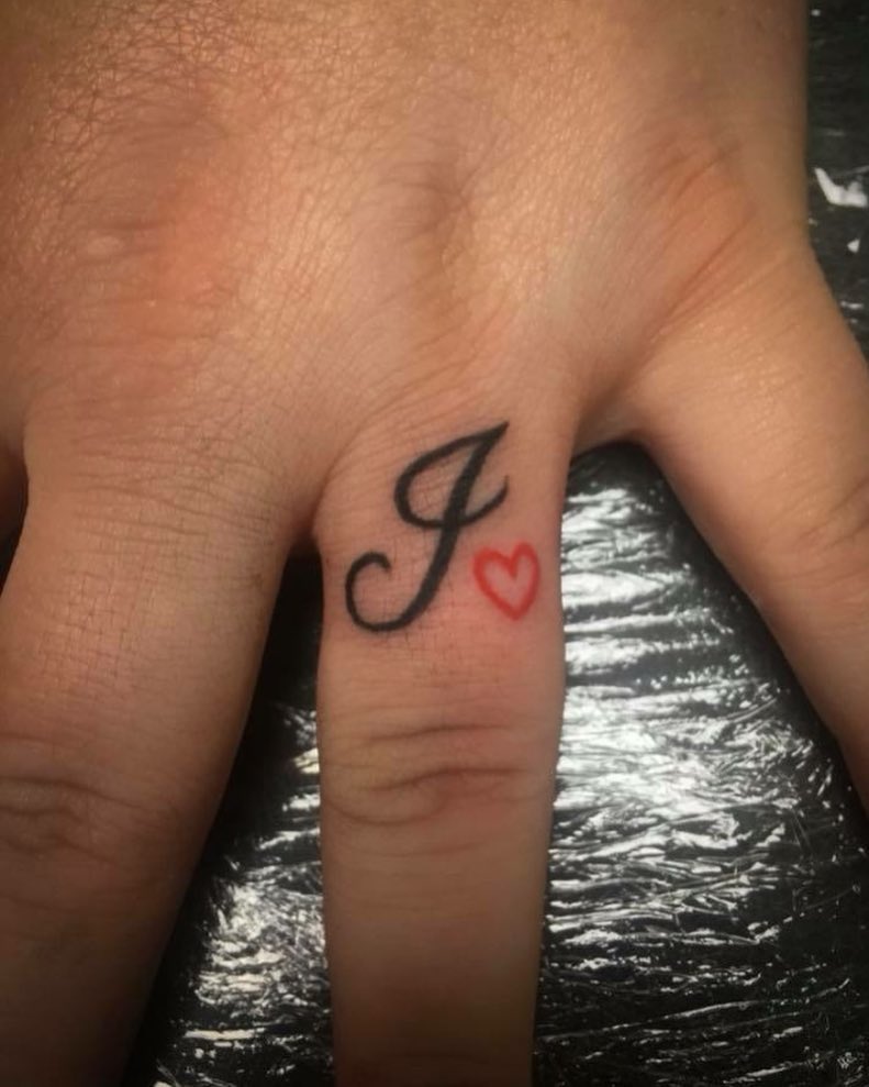 Initial Tattoo With Red Heart Outline On Ring Finger