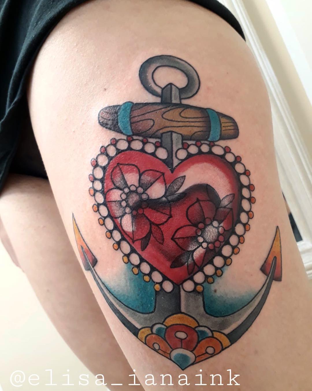Colorful anchor tattoo with heart on thigh