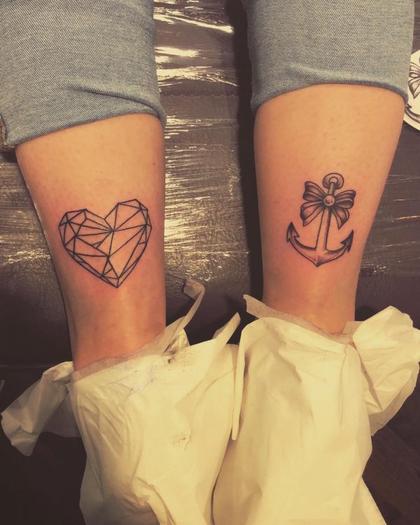 Geometric heart and anchor tattoo on legs