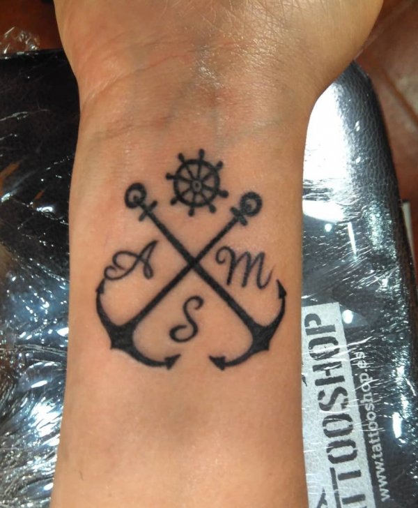 Lettering tattoo with anchor on wrist