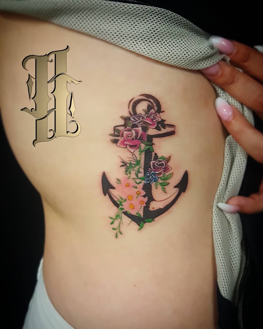 Wow flower decorated anchor tattoo on ribs