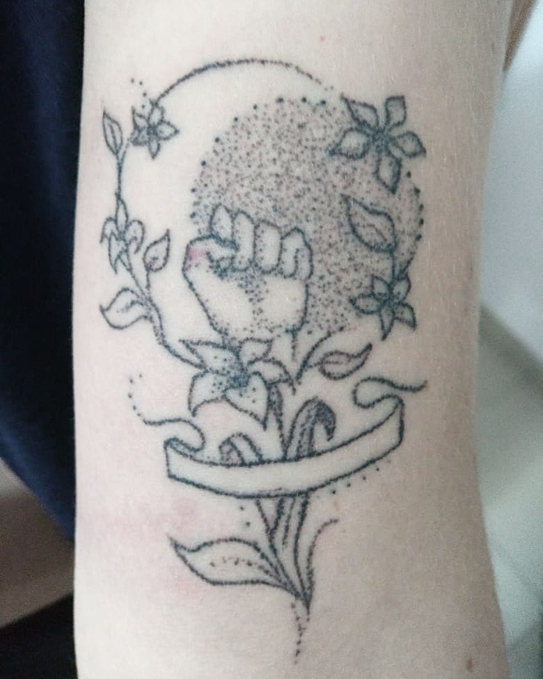 Adorable dot work feminist tattoo on arm. Pic by handpokenomad