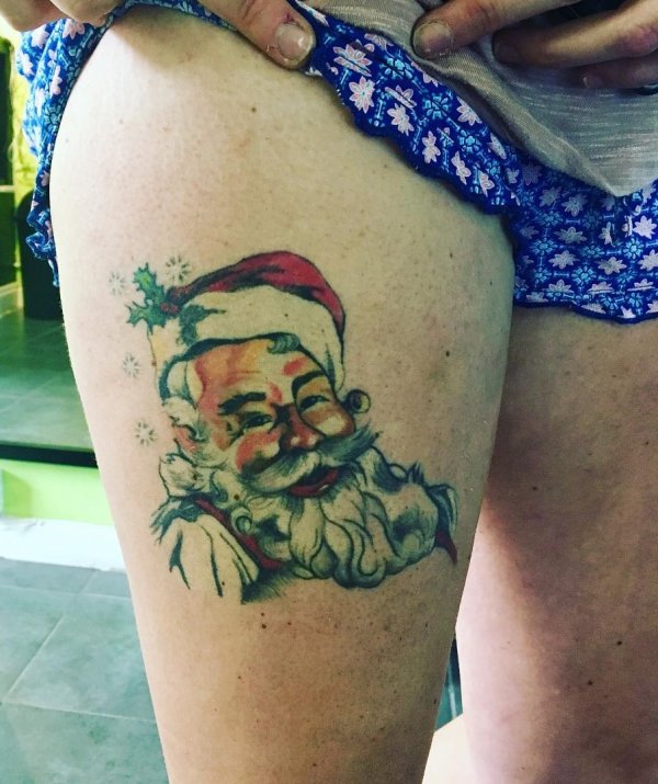 Cozy santa tattoo on thigh