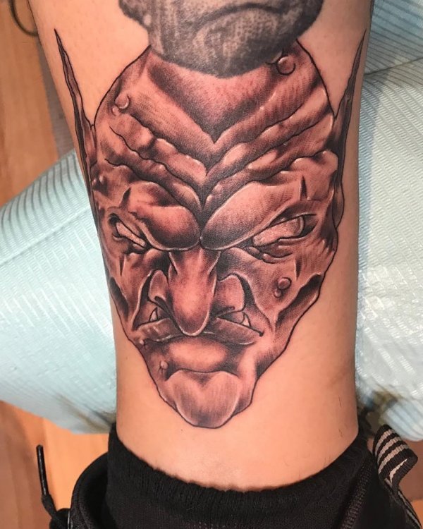 Evil face tattoo on lower leg. Creepy Tattoo Ideas