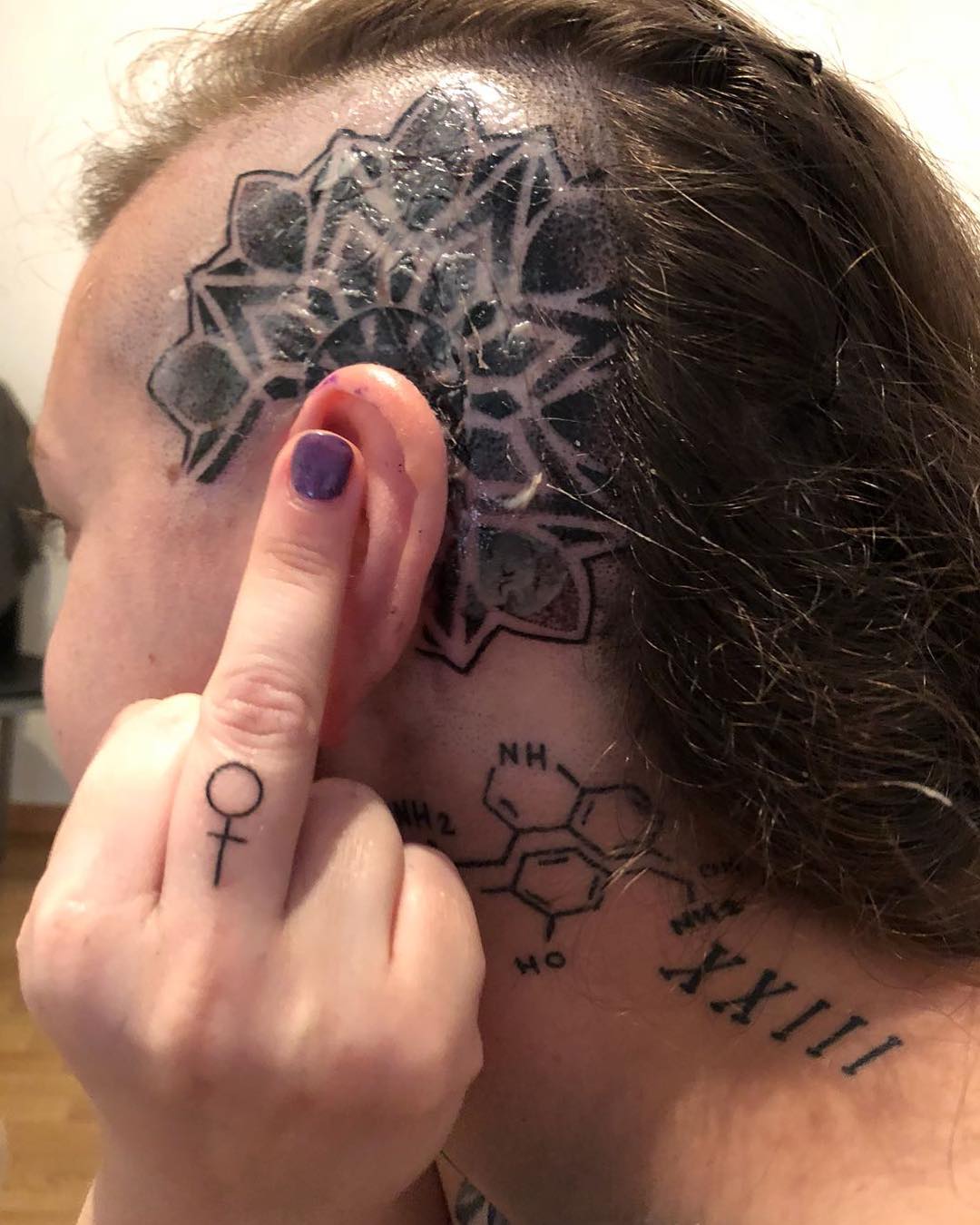 Head and middle finger feminist tattoo. Pic by mary___volkova