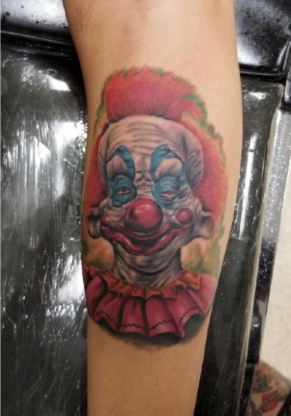 Killer clown tattoo on arm. Pic by lostharbortattoo