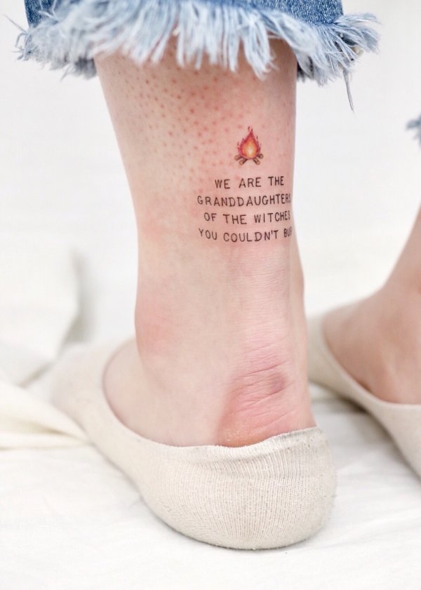 Perfect feminist tattoo with fire on lower leg. Pic by studiobysol