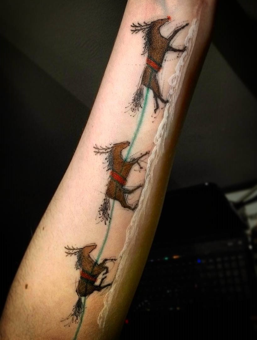 Striking reindeer Christmas tattoo on arm.