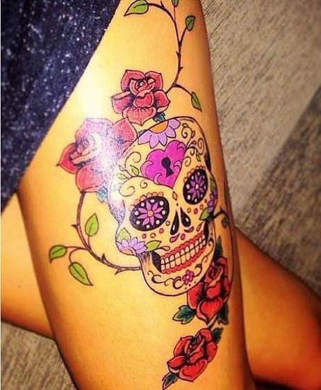 A beautiful skull tattoo with roses on thigh.