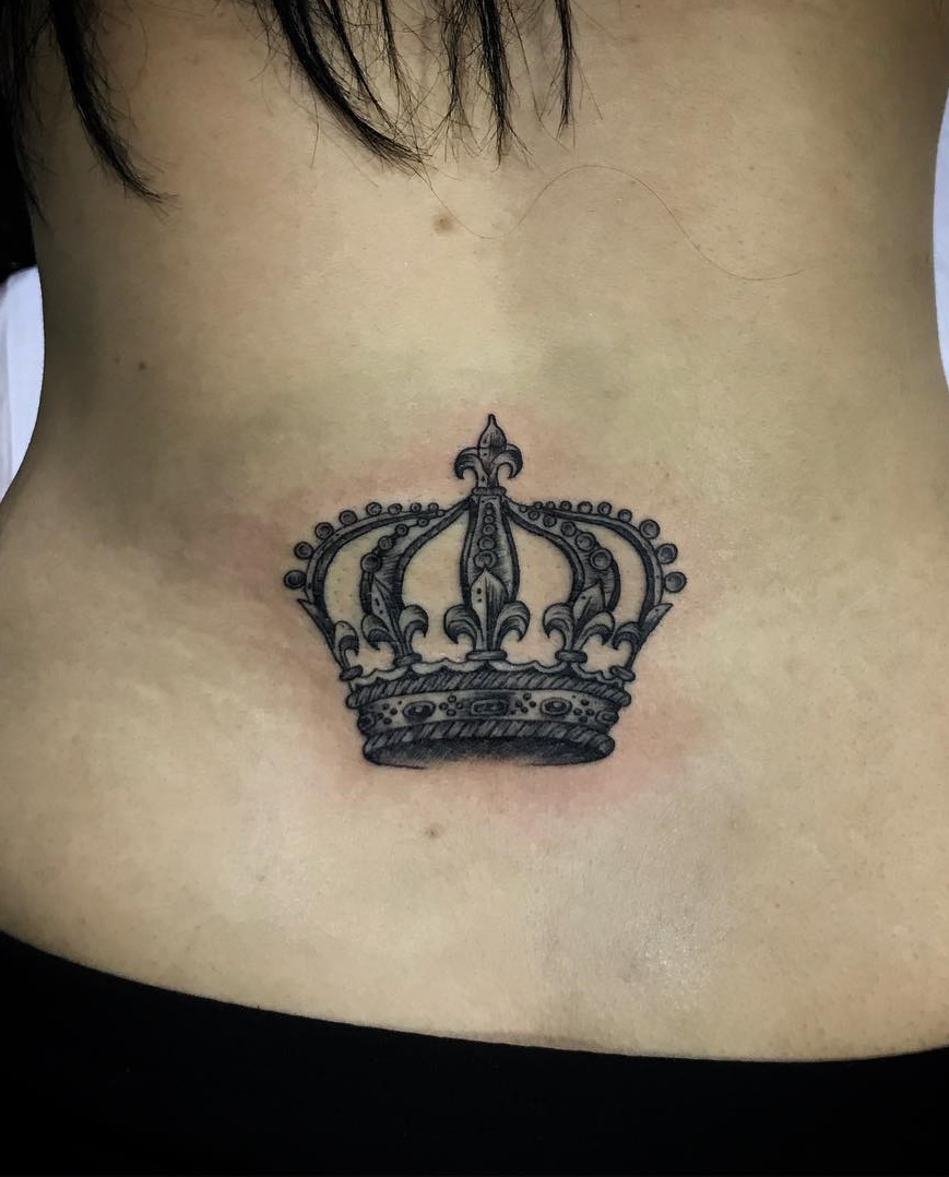 A crown on the wearer lower back in black and grey.