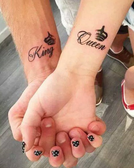 A simplified pair of king and queen crowns on wrist with word.