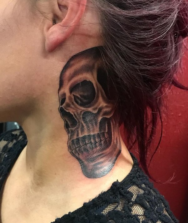 Black and grey skull tattoo on neck.