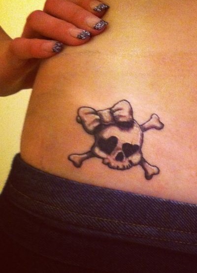 Black and grey skull with cross bones inked on side back.