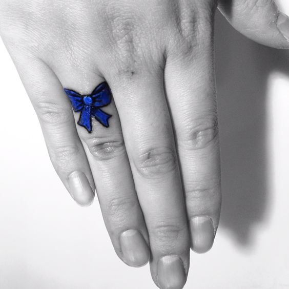 Charismatic blue ribbon tattoo on ring finger.
