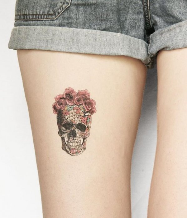 Chic geometric Skull tattoo with floral wreath on thigh.