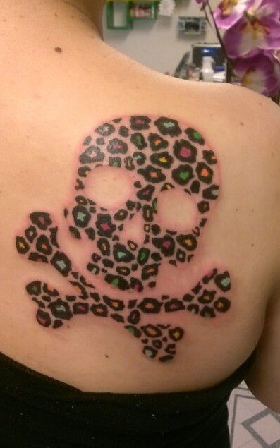 Cool cheetah print skull, and crossbones tattoo on back shoulder.