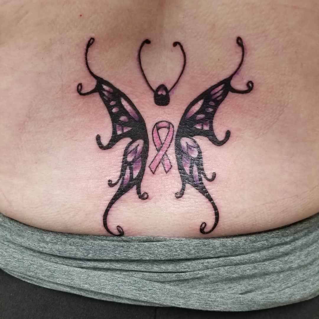 Cute butterfly ribbon tattoo on lower back.