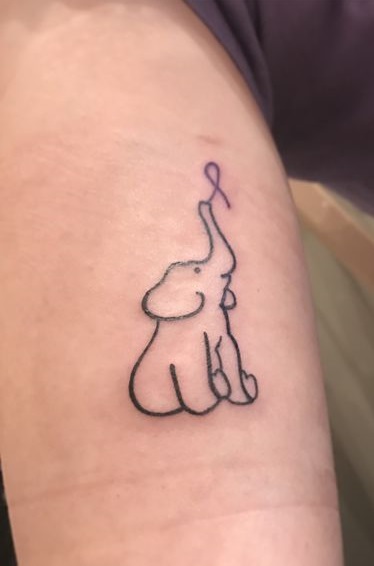 Elephant holding purple ribbon sleeve tattoo which is the sign of Alzheimer.