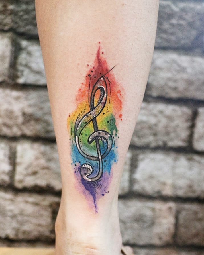 Rainbow music key watercolor tattoo on lower leg.