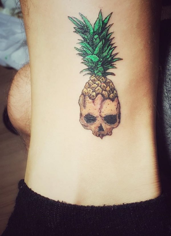 Rocking Pineapple skull tattoo on ankle.