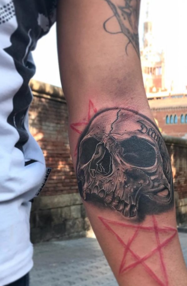 Scary black and grey skull tattoo on arm.