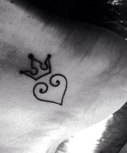 Single line heart and crown tattoo on foot.
