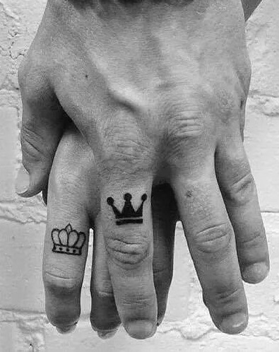 Small king and queen couple tattoo set on middle fingers.