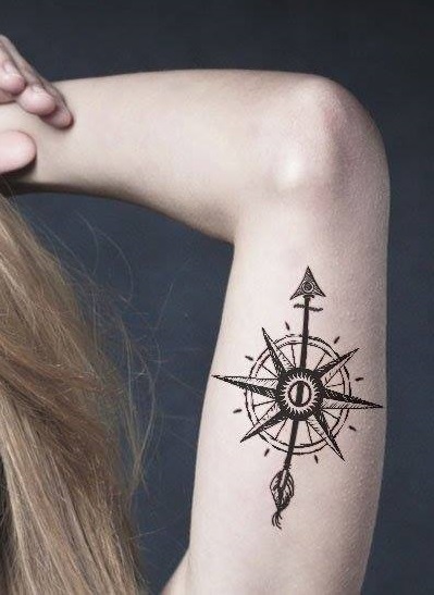 This arm tattoo features curvy shapes and a broken circular outline.