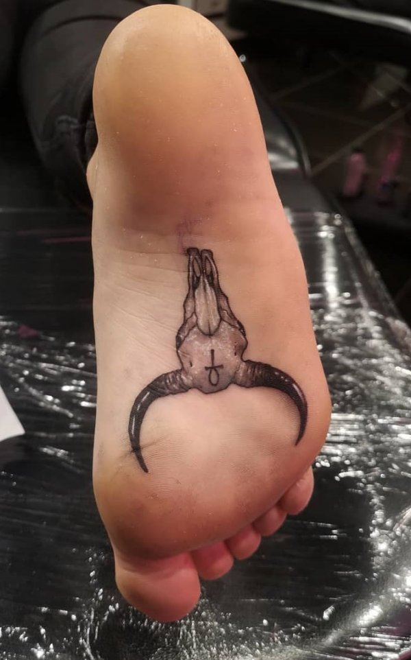 Unusual goat skull foot tattoo idea.