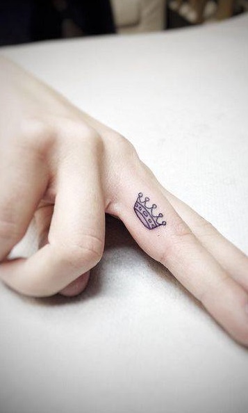 Wonderful royal crown piece inked on middle finger.