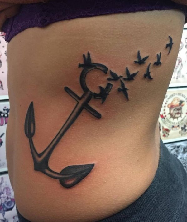 An anchor tattoo that looks like it is falling apart at the top.