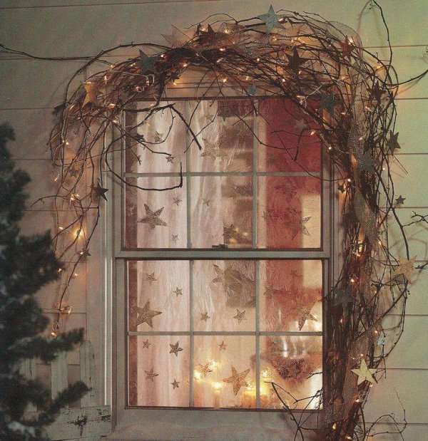 Dashing grapevine garland and rusty touch stars gives rustic touch to outside window.