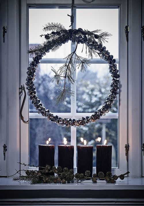 Gorgeous jingle bell wreath with wooden box candles for window decoration at Christmas.