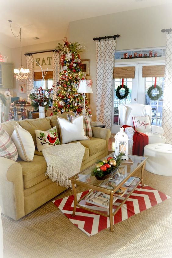 Majestic living room decoration wit Christmas tree, garland and red & white mat.