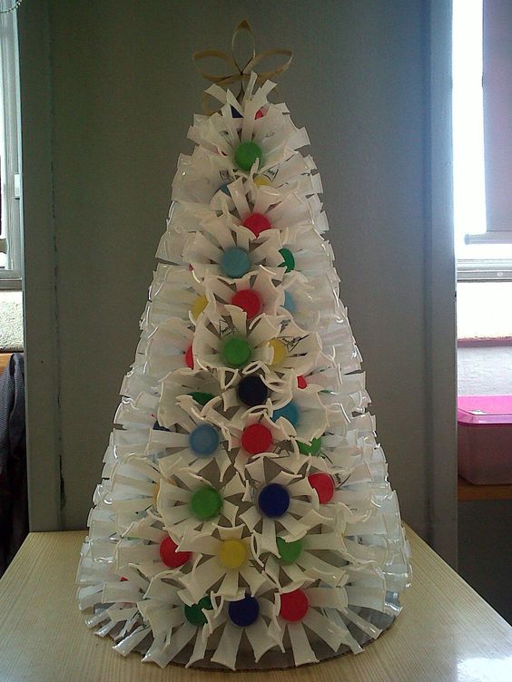 Plastic glasses attached with pom-pom arranges as Christmas tree.
