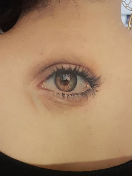 Realistic eyeball tattoo looks perfect on Upper back.