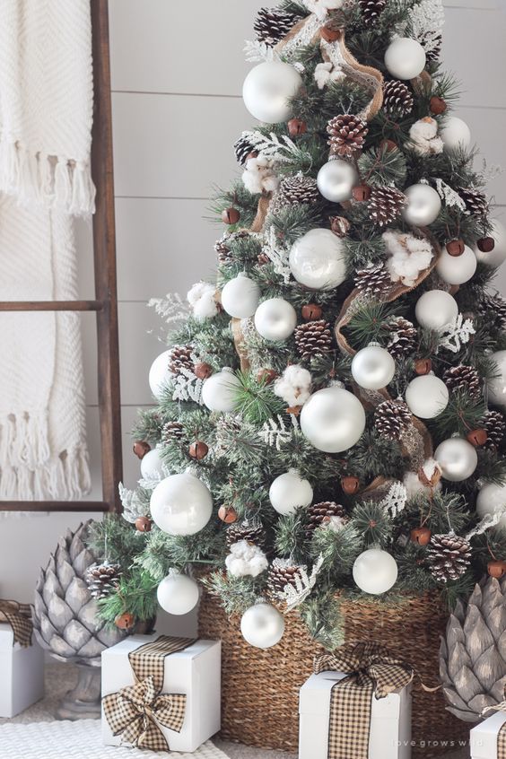 Stunning farmhouse style Christmas tree decoration with white balls , pinecones and gifts.