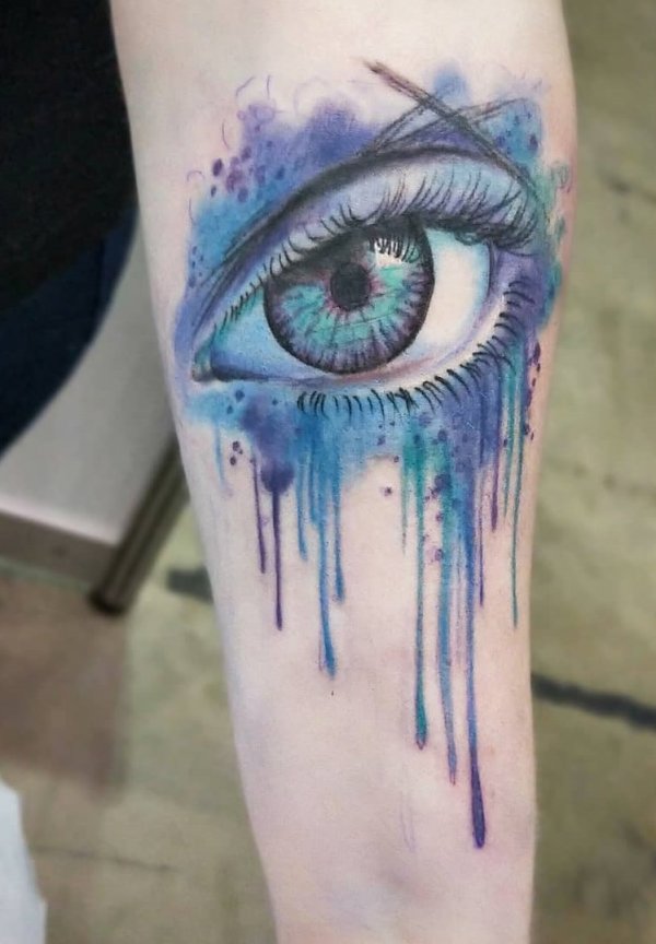 Watercolor deep blue eye tattoo on arm.