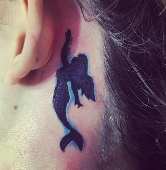 A tiny mermaid in black behind the ear.