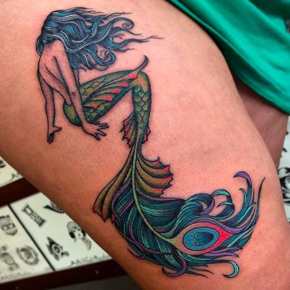 Amazing peacock feather mermaid tattoo design.