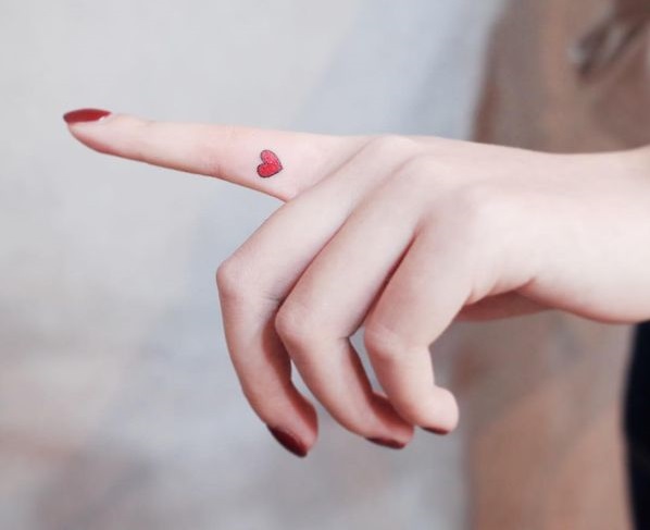 Amazing red heart finger tattoos for women.