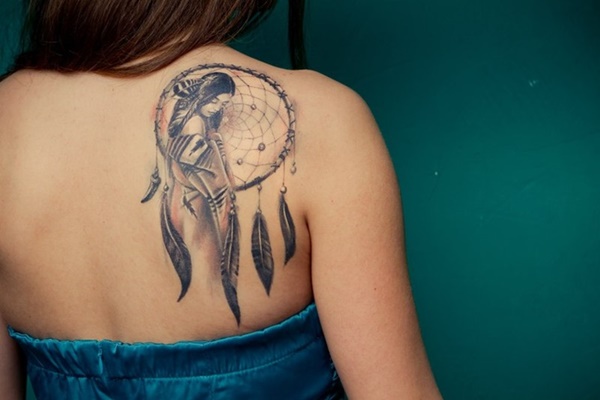 Artistic dreamcatcher tattoo with portrait on back shoulder.
