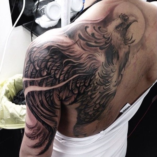 Artistic phoenix tattoo on one side of back.
